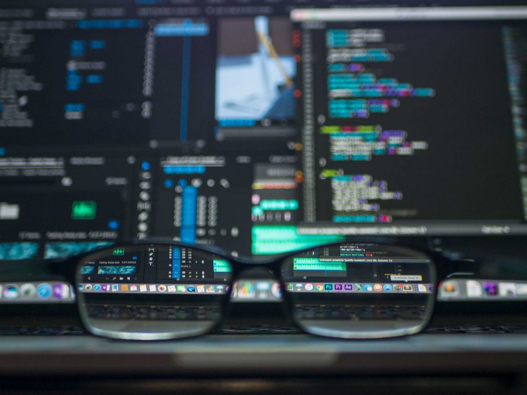 Glasses in front of computer screens with code